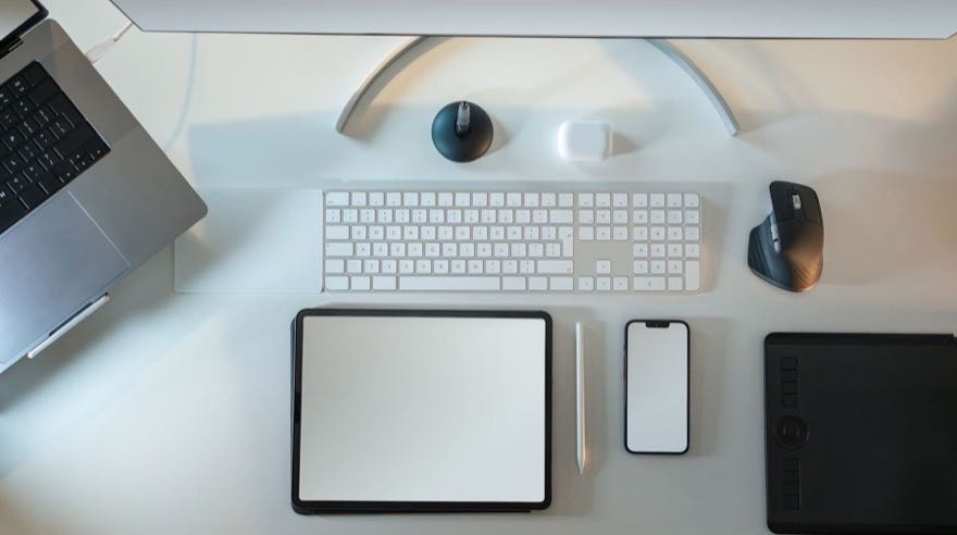 Laptop, tableta, teléfono y teclado sobre un escritorio